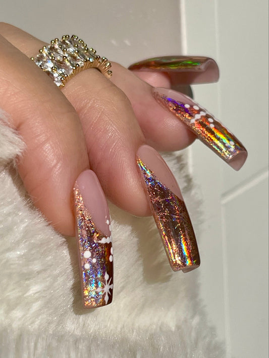 Close-up of a hand with iridescent nail polish and a ring on a white background
