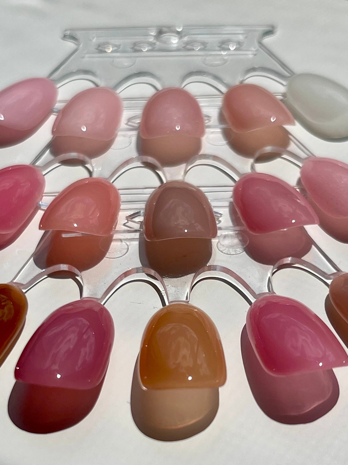 Set of artificial nails in various colors on a display stand.