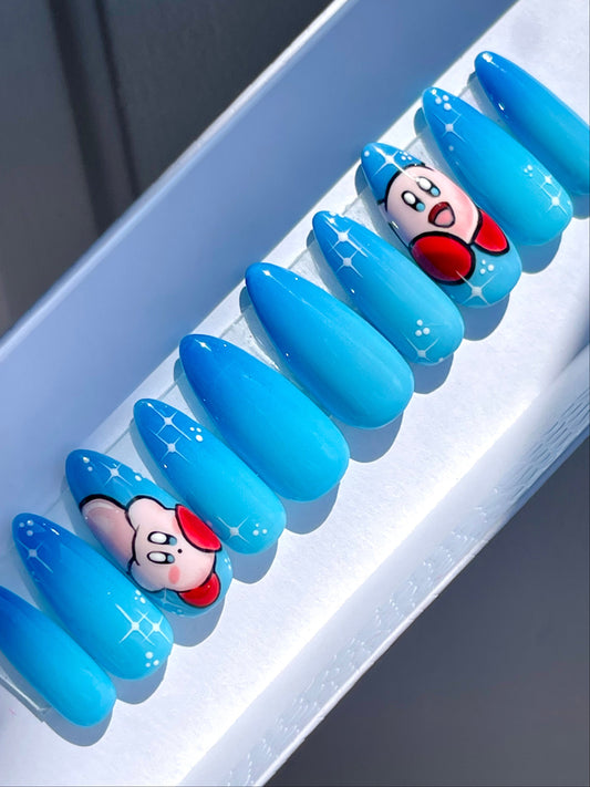 Blue ombre nails with cartoon character design on a white tray