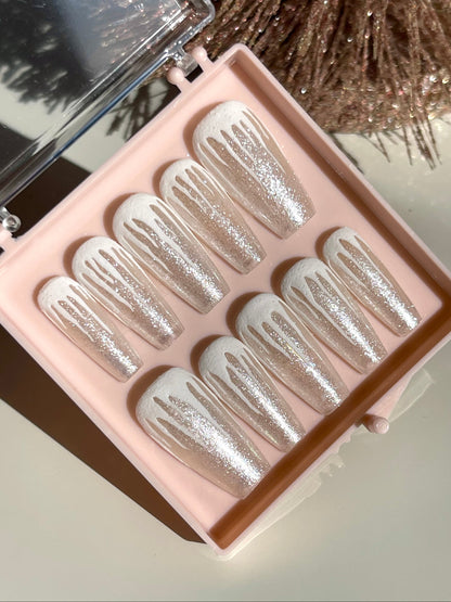 Set of glittery false nails in a pink case with a blurred background