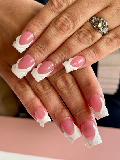 Close-up of a hand with pink nails and a silver ring, wearing clear nail wraps.