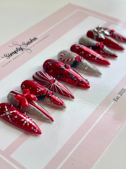 Red and silver decorative nails on a Simply Sasha branded card.