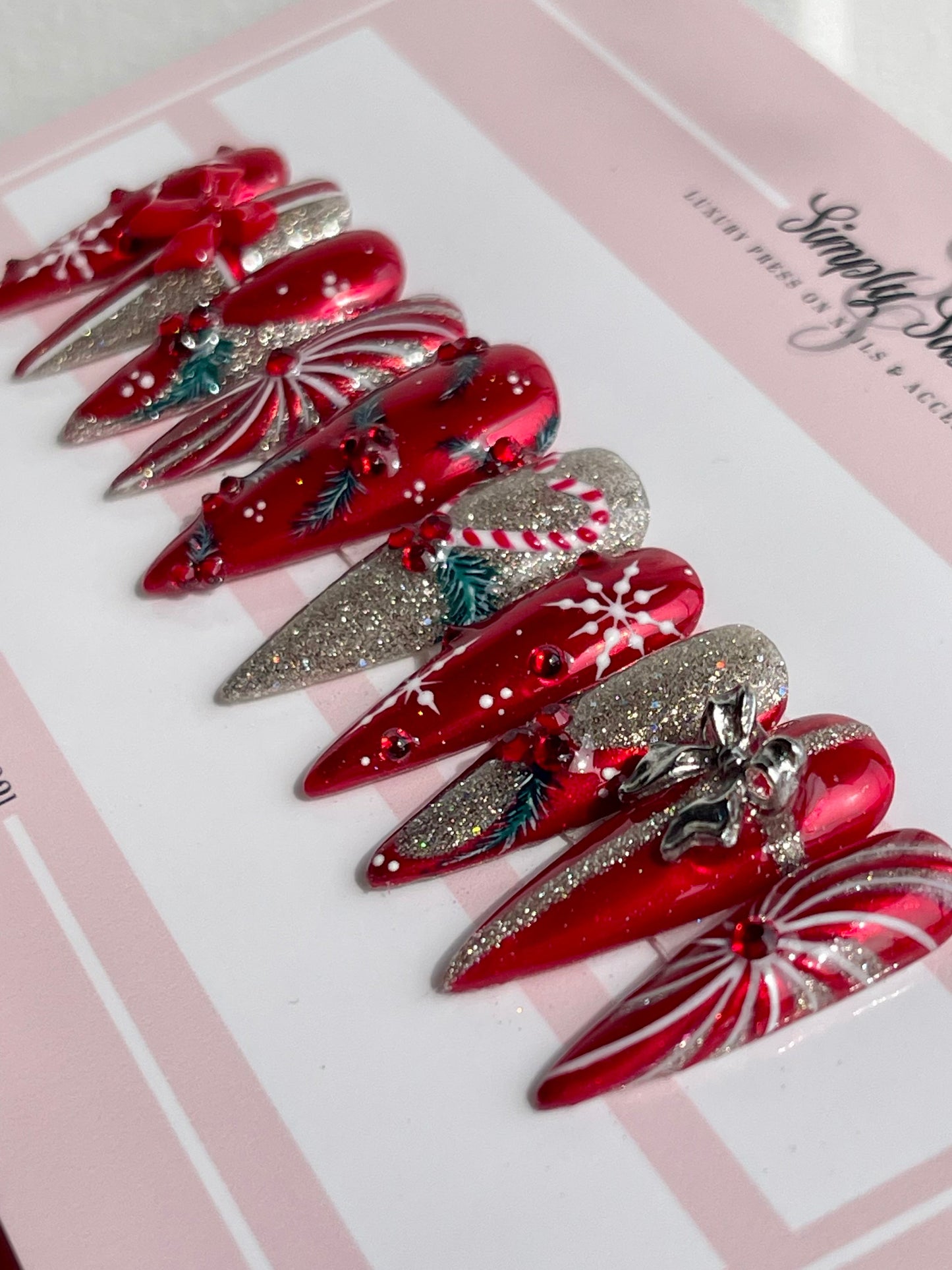 Red and silver hair clips on a pink and white background with 'Sassie' branding.