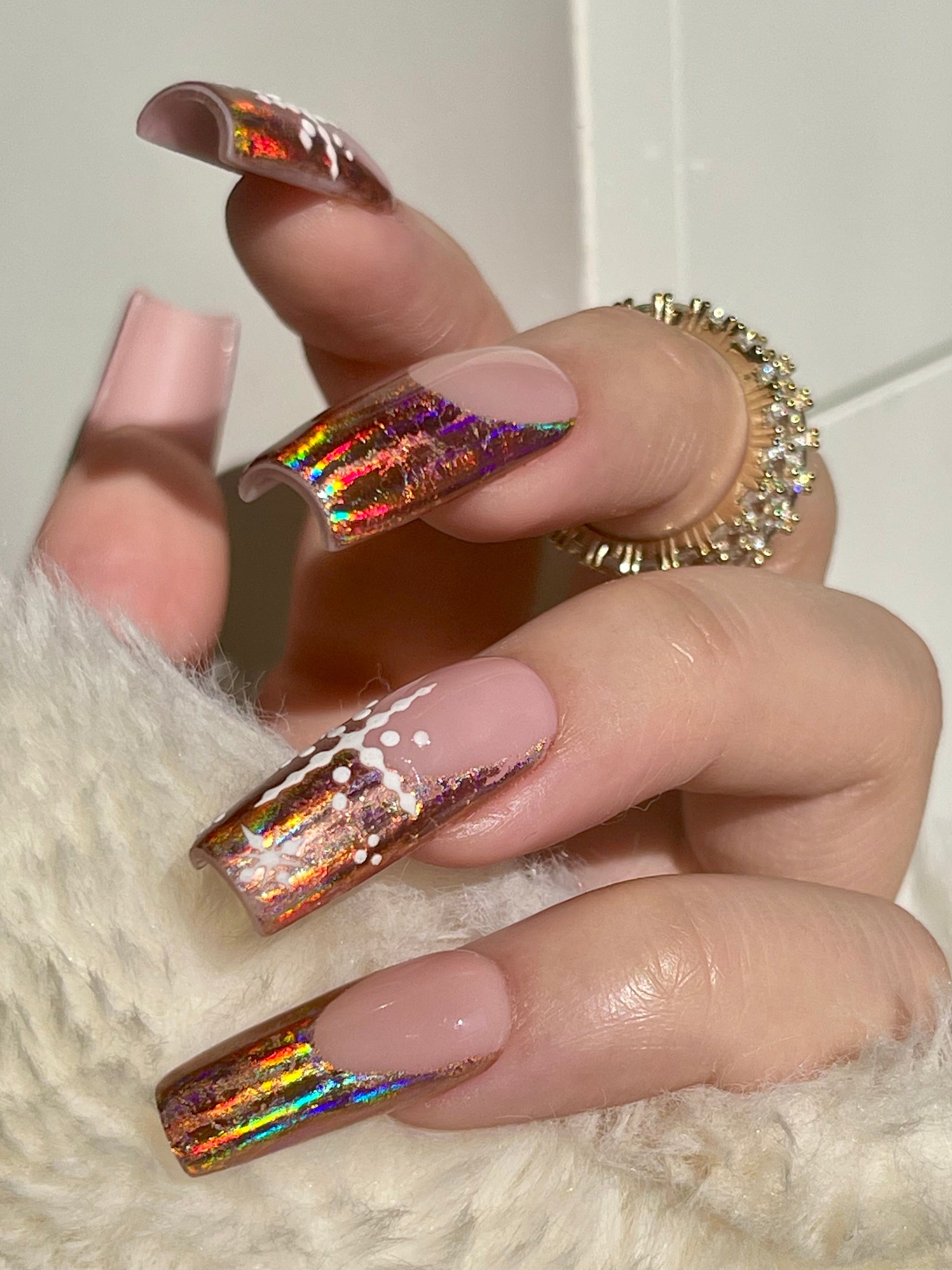 Hand with iridescent nail polish on a white background