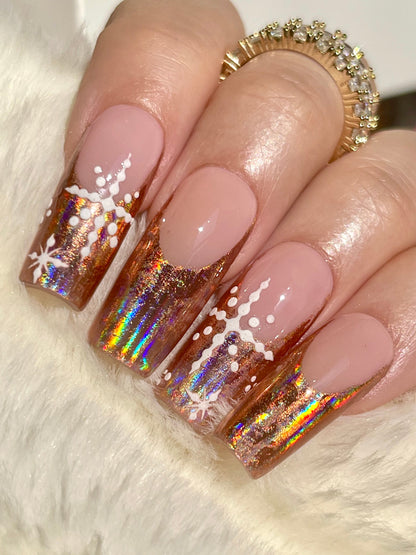 Nails with iridescent design and white snowflake decorations on a fluffy white background