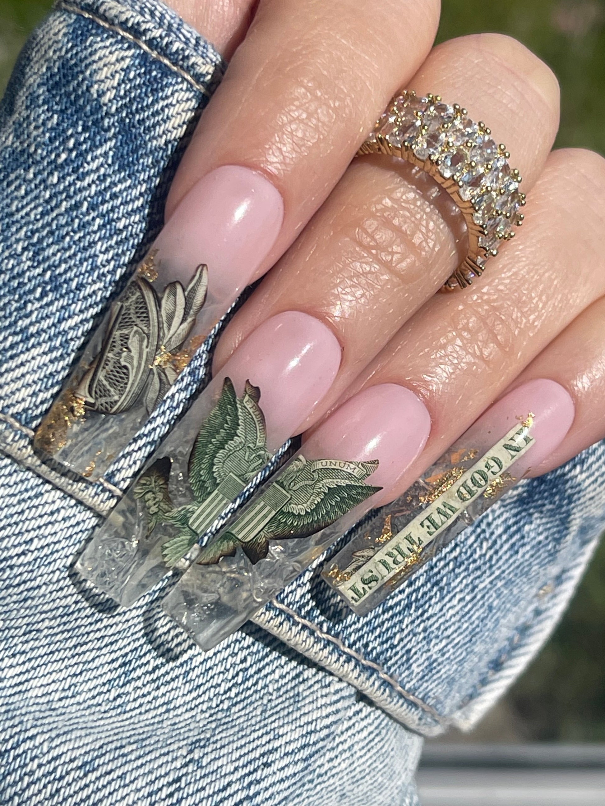 Close-up of a hand with decorative nails on a denim background