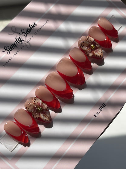 Nail art display with red and beige designs on a striped background