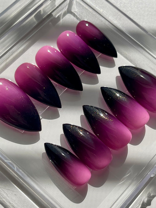Purple and black gradient nail tips on a clear tray